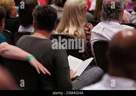 East Lansing, États-Unis. 23 juillet 2024. Un membre du public lit un exemplaire de True Gretch lors d'un arrêt sur la tournée de livres du gouverneur Gretchen Whitmer à East Lansing, Mich., le 23 juillet 2024. (Photo de Andrew Roth/Sipa USA) crédit : Sipa USA/Alamy Live News Banque D'Images