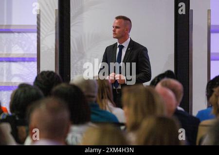 East Lansing, États-Unis. 23 juillet 2024. Un membre des services de sécurité du gouverneur Gretchen Whitmer surveille le public lors d'un arrêt lors de la tournée du livre « True Gretch » de Whitmer à East Lansing, Mich., le 23 juillet 2024. (Photo de Andrew Roth/Sipa USA) crédit : Sipa USA/Alamy Live News Banque D'Images