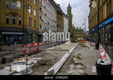 Marche amélioration du cyclisme créant une zone piétonne (hommes travaillant, travaux routiers, trottoir fermé) - Transforming Bradford, West Yorkshire England UK Banque D'Images