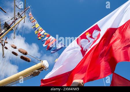 MARIEHAMN, Åland, FINLANDE - JUILLET 25 2024 : drapeaux sur la poupe du grand voilier polonais Dar Mlodziezy. Deuxième jour des trois jours Åland Stage de la course de grands voiliers 2024 dans le port principal, Mariehamn, Åland, Finlande. Photo : Rob Watkins/Alamy Live News. INFO : la Tall Ships Race est un événement annuel de voile mettant en vedette des grands voiliers historiques et modernes. Il promeut l'amitié internationale et la formation des jeunes, attirant des participants et des spectateurs du monde entier pour célébrer le patrimoine maritime et l'art de la voile traditionnelle. Banque D'Images