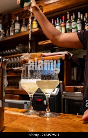 Versement spécial de txakoli ou chacolí vin blanc légèrement mousseux très sec dans des verres, produit dans le pays basque espagnol dans le bar pinchos typique Banque D'Images