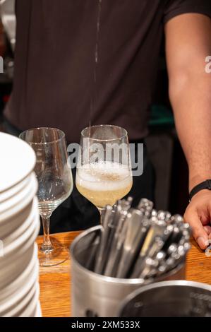 Versement spécial de txakoli ou chacolí vin blanc légèrement mousseux très sec dans des verres, produit dans le pays basque espagnol dans le bar pinchos typique Banque D'Images