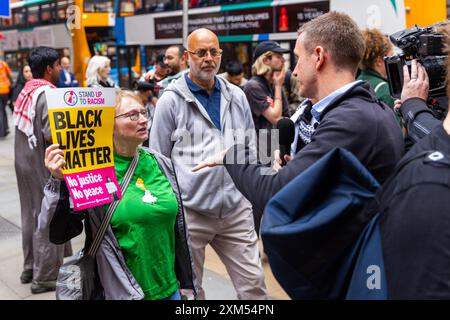 Manchester, Royaume-Uni. 25 JUILLET 2024. L'activiste est interviewé alors que les manifestants se rassemblent pour manifester contre une vidéo diffusée depuis l'aéroport de Manchester dans laquelle des agents des armes à feu du GMP ont été vus en train d'utiliser la force contre des manifestants, l'incident étant renvoyé à l'IPCC. Les manifestants ont bloqué les tramways et la circulation à St Peters Square sans intervention de la police. Les manifestants se sont dispersés après environ 2 heures. Crédit Milo Chandler/Alamy Live News Banque D'Images