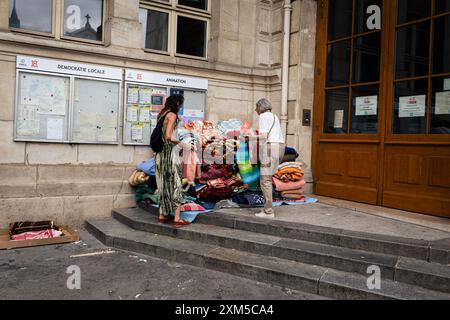 Des bénévoles aident à entreposer les couvertures utilisées par les familles de sans-abri lors de l’occupation de la place Jules Joffrin, en face de la mairie du 18e arrondissement. Des dizaines de familles migrantes sans abri ont passé trois jours et deux nuits sur la place Jules Joffrin, devant la mairie du 18ème arrondissement, à Paris, pour revendiquer leur droit au logement. Une unité de police était en place, formant un périmètre, ne permettant à personne de sortir ou d'entrer, ce qui a entraîné la séparation des familles. Ce n'est que le troisième jour que la préfecture a trouvé un logement en Ile de France, mais elle ne savait pas combien de temps l'abri Banque D'Images