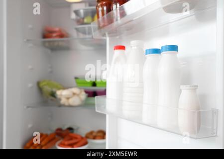 Bouteilles de lait frais sur la porte du réfrigérateur. Gros plan Banque D'Images