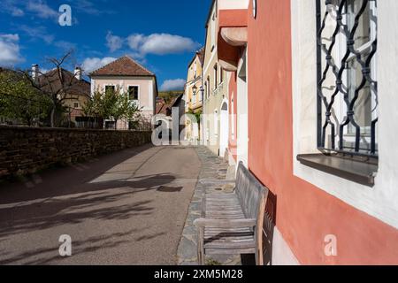 Wachau, Autriche - 26 octobre 2023 : Une rue étroite à Wachau, Autriche avec des bâtiments colorés et un banc en bois. Banque D'Images