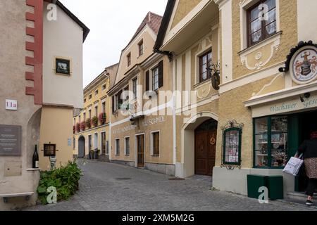 Wachau, Autriche - 26 octobre 2023 : Une rue pavée à Wachau, Autriche avec des bâtiments colorés et une vitrine. Banque D'Images