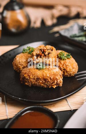 une assiette de nourriture contenant plusieurs morceaux de croquettes Banque D'Images