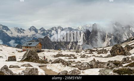 Randonnée sur le circuit Tre Cime en juin : neige et brouillard se mêlent aux sommets spectaculaires des Dolomites. Banque D'Images