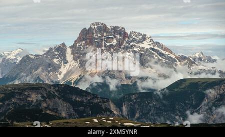 Circuit de tre Cime en juin : sentiers enneigés et sommets des Dolomites révélés par intermittence à travers le brouillard Banque D'Images