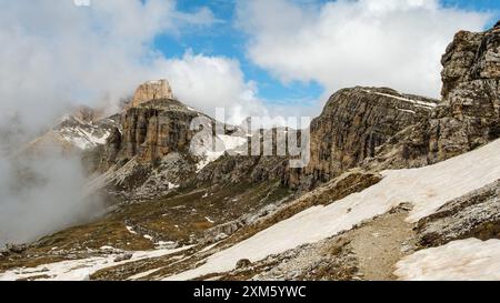 Randonnée sur le circuit Tre Cime en juin : mélange de neige et de brouillard pour mettre en valeur les superbes sommets des Dolomites. Banque D'Images