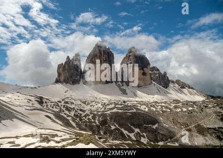 Randonnée dans la neige et le brouillard sur le circuit de Tre Cime, avec des sommets des Dolomites émergeant à travers les nuages brumeux Banque D'Images