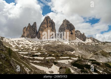 Dolomites révélées à travers le brouillard : Snowy Tre Cime circuit Trail en juin avec des pics émergeant de la brume. Banque D'Images