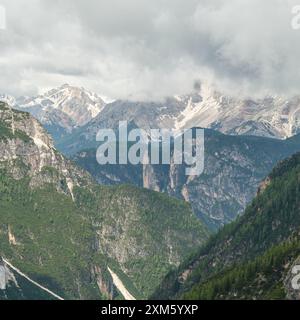 Dolomites en juin : circuit enneigé de Tre Cime avec des pics émergeant à travers une brume et des nuages imprévisibles Banque D'Images