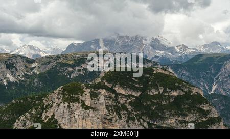 Circuit Tre Cime de juin : sentiers enneigés et sommets des Dolomites se mélangeant dans un paysage brumeux et spectaculaire Banque D'Images