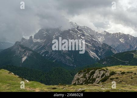 Dolomites en juin : circuit enneigé de Tre Cime avec des pics partiellement visibles à travers la brume brumeuse. Banque D'Images