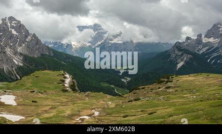 Circuit tre Cime en juin : terrain enneigé et sommets Dolomites émergeant par intermittence des nuages Banque D'Images