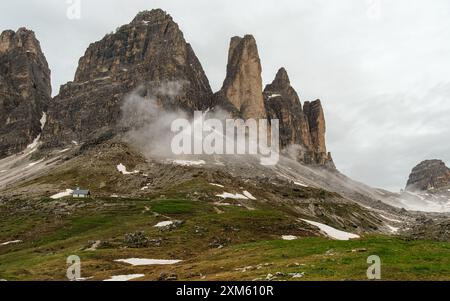 Le sentier enneigé du circuit Tre Cime de juin avec des sommets Dolomites émergeant à travers le brouillard mouvant Banque D'Images