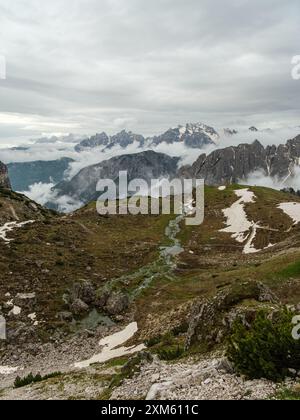 Le circuit enneigé de Tre Cime de juin avec des sommets Dolomites émergeant à travers le brouillard tourbillonnant. Banque D'Images