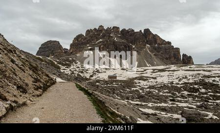 Allure enneigée des Dolomites : randonnée sur le circuit Tre Cime en juin avec des pics brumeux et un temps spectaculaire Banque D'Images