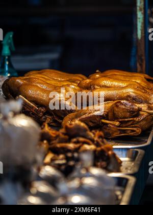 Canard rôti exposé à la vente dans un marché nocturne. Banque D'Images