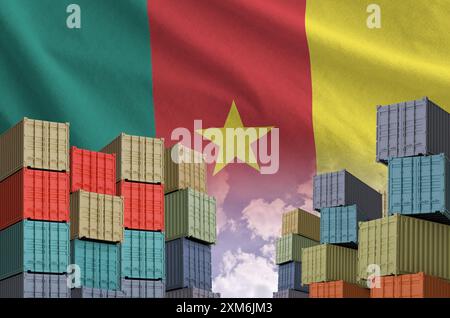 Drapeau du Cameroun et grande pile de conteneurs de fret maritime dans les docks avec fond de ciel de près Banque D'Images