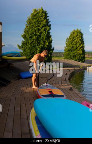 Homme pompe le SUP gonflable. Banque D'Images