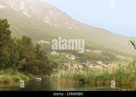 Matin brumeux au bord de la rivière dans une petite ville charmante d'Akyaka dans la province de Mula, Turquie. Banque D'Images