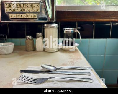 Table à manger américaine classique avec ustensiles, sirop, sucre, juke-box Banque D'Images