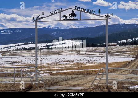 Porte de ranch en fer forgé sur Enchanted Circle Byway près d'Eagle Nest avec les montagnes Sangre de Christo dans la distance. Dans le comté de Colfax, Nouveau-Mexique, États-Unis Banque D'Images