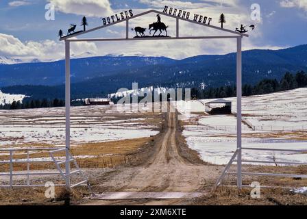 Porte de ranch en fer forgé sur Enchanted Circle Byway près d'Eagle Nest avec les montagnes Sangre de Christo dans la distance. Dans le comté de Colfax, Nouveau-Mexique, États-Unis Banque D'Images