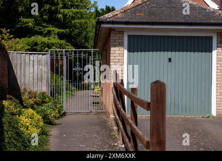 La porte décorative attrayante en métal marque une limite claire à l'entrée du jardin d'une maison privée à Framlingham, une ville de marché du Suffolk. Banque D'Images