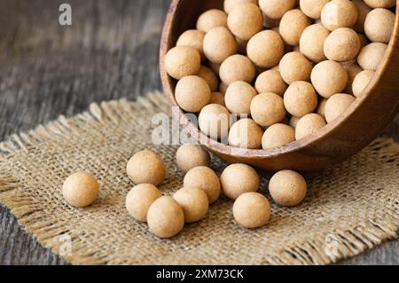 Pois chiches recouverts de soja marron avec sauce dans un bol en bois, noix turque traditionnelle enrobée Banque D'Images