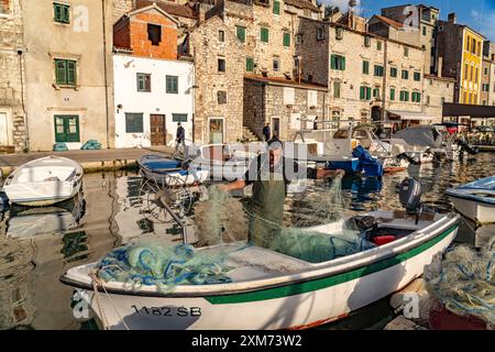 Pêcheur avec filet sur son bateau au petit port de la vieille ville de Sibenik, Croatie, Europe Banque D'Images