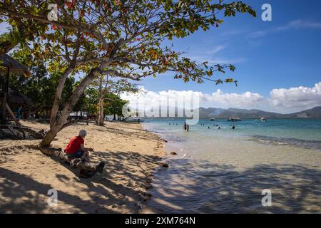 Les gens se détendent sur la plage et dans l'eau à Cowrie Island, Honda Bay, près de Puerto Princesa, Palawan, Philippines Banque D'Images