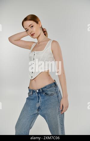 Une jeune femme portant un corset blanc pose sur un fond blanc. Banque D'Images