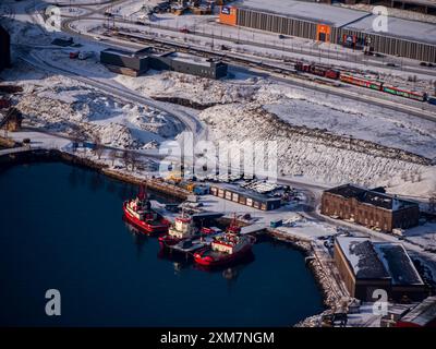 Narvik, Norvège - mars 2023 : vue aérienne du port de transbordement du minerai de fer de la mine suédoise de Kiruna et de trois remorqueurs rouges. Ofotf Banque D'Images