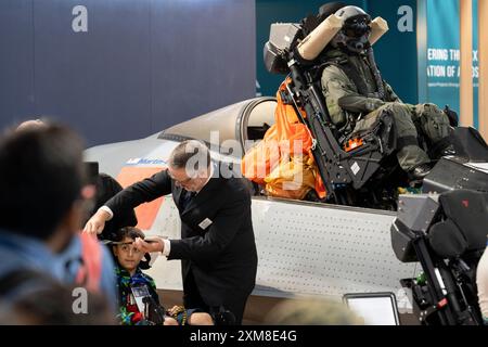 Les visiteurs participent avec la technologie de siège éjectable de la société Martin-Baker lors du salon aéronautique international de Farnborough, le 26 juillet 2024, à Farnborough, en Angleterre. Martin-Baker est un fabricant britannique de sièges éjectables et d'équipements de sécurité pour l'aviation qui affirme que depuis le premier test d'éjection en direct en 1945, un total de 7 674 vies ont été sauvées grâce aux sièges éjectables de la société. Le salon aéronautique international de Farnborough, qui se déroule cette année, accueille 1 500 exposants avec 100 000 m2 d'espace d'exposition avec plus de 80 000 visiteurs sur les 5 jours de commerce. Banque D'Images