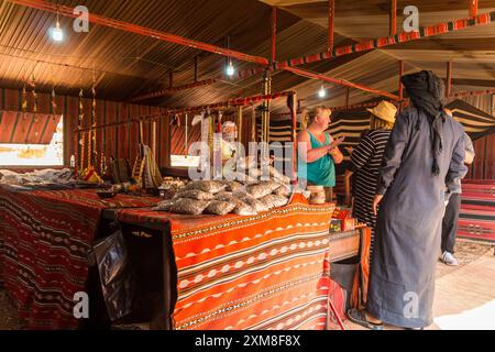 Touristes regardant des souvenirs dans un campement bédouin, Wadi Rum, Jordanie Banque D'Images