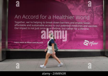 New York, États-Unis. 25 juillet 2024. Une personne passe devant un panneau à l'extérieur du bâtiment du siège mondial de Pfizer à Manhattan, New York. (Crédit image : © Jimin Kim/SOPA images via ZUMA Press Wire) USAGE ÉDITORIAL SEULEMENT! Non destiné à UN USAGE commercial ! Banque D'Images