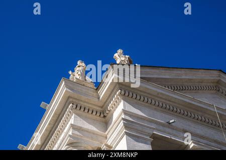 Vatican - 1er octobre 2019 : statues au sommet d'un ancien bâtiment contre un ciel bleu clair. Banque D'Images