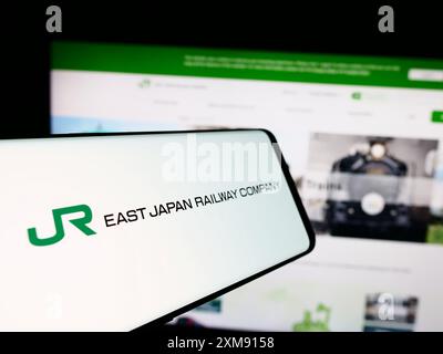 Smartphone avec logo de l'entreprise ferroviaire japonaise East Japan Railway Company devant le site Web. Mettez l'accent sur le centre-gauche de l'écran du téléphone. Banque D'Images