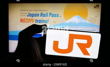 Personne tenant un smartphone avec le logo de l'entreprise ferroviaire japonaise Central Japan Railway Company en face du site Web. Concentrez-vous sur l'affichage du téléphone. Banque D'Images