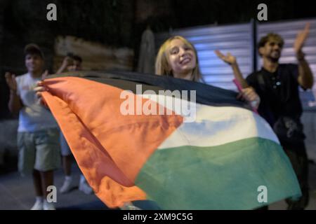 Rome, Italie. 26 juillet 2024. Quelques jeunes garçons, venus de Tunisie, du Maroc et d’Egypte, animaient la place devant le Colisée avec de la musique arabe qui faisait danser les touristes et invitait les touristes à danser avec le drapeau palestinien à Rome. (Crédit image : © Marcello Valeri/ZUMA Press Wire) USAGE ÉDITORIAL SEULEMENT! Non destiné à UN USAGE commercial ! Banque D'Images