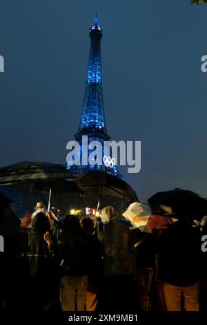 Paris, Ile de France, France. 27 juillet 2024. Les spectateurs baignés de pluie regardent les cérémonies d'ouverture des Jeux Olympiques d'été de Paris 2024 depuis les rives de la Seine devant la Tour Eiffel, Paris, France. (Crédit image : © Angel Adams/ZUMA Press Wire) USAGE ÉDITORIAL SEULEMENT! Non destiné à UN USAGE commercial ! Crédit : ZUMA Press, Inc/Alamy Live News Banque D'Images