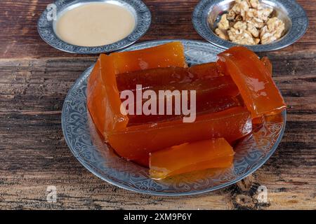 Dessert turc traditionnel à la citrouille (tatlisi kabak). Dessert turc à la citrouille croustillante de Hatay, Kirecte Kabak Tatlisi avec poudre de noix. Banque D'Images