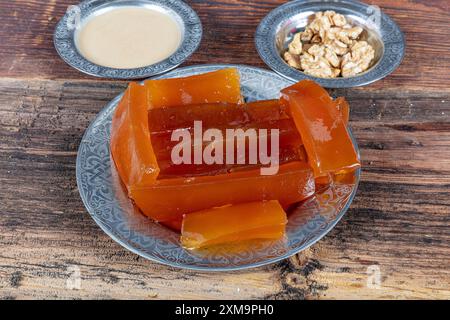 Dessert turc traditionnel à la citrouille (tatlisi kabak). Dessert turc à la citrouille croustillante de Hatay, Kirecte Kabak Tatlisi avec poudre de noix. Banque D'Images