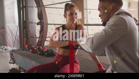 Image de données d'entraînement de boxe au-dessus d'athlètes enveloppant les mains dans la salle de gym Banque D'Images