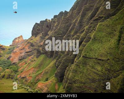 Vue aérienne depuis un hélicoptère de vol au-dessus de la côte Na Pali sur l'île hawaïenne de Kaua'i, Hawaï, États-Unis. Les falaises le long du rivage s'élèvent jusqu'à 1 200 mètres (4 000 pieds) au-dessus de l'océan Pacifique. Banque D'Images