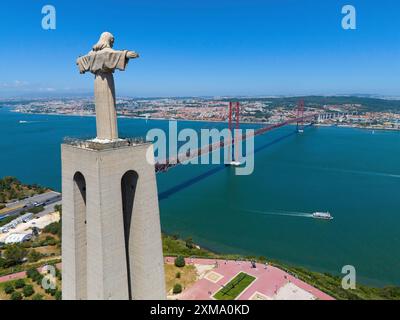 Statue avec les bras tendus sur un point de vue à côté d'un pont rouge et un vaste paysage urbain en arrière-plan, vue aérienne, Statue Cristo Rei Banque D'Images